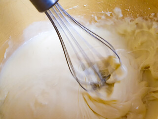 Whipping cream and butter cream with a mixer or blender, preparing cream filling. Mixing butter and...
