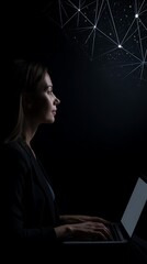 Silhouette of a person working on a laptop at night.