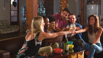 Group Of Young Friends Celebrating At Evening Drinks Party In Loft Apartment