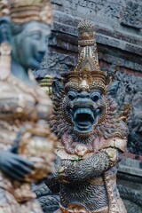 Balinese statues guard a temple entrance in Ubud, Bali, Indonesia. The intricate carvings and vibrant colors showcase the island's rich cultural heritage.