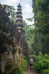 Tourists explore the ancient Pura Gunung Lebah temple complex in Ubud, Bali, Indonesia. The...