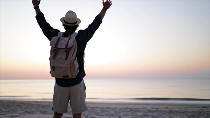 A young man strolls along the sandy beach as the sun sets, casting a warm glow over the water. The serene atmosphere invites relaxation and reflection - Powered by Adobe