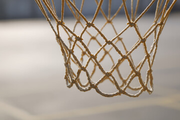 Basketball hoop with net on urban court in soft golden light