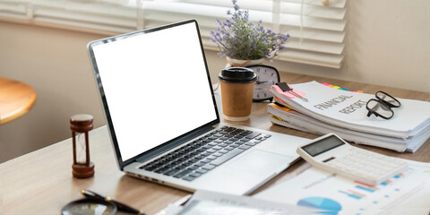 Workspace and Productivity. Laptop and financial documents on a desk with coffee.