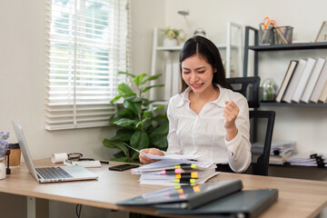 Workplace Success. Happy woman celebrating achievement at desk.