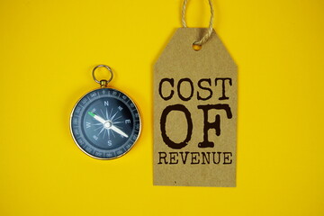 Cost Of Revenue text on price tag with compass on yellow background
