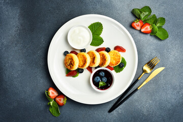 Breakfast. Cottage cheese pancakes with berries, jam and sour cream. Healthy meal.