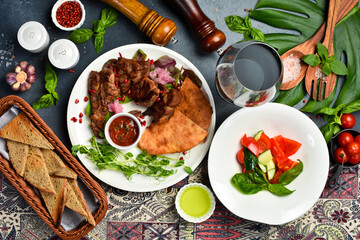 Food background. Fresh kebab, fresh vegetables and Georgian bread in a plate. Top view.