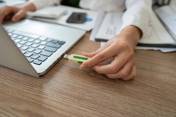 Digital Transformation. Business professional inserting USB drive into laptop.