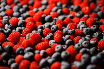 background. The surface is covered with raspberries and blueberries.