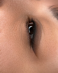 Close-up of a human eye with detailed iris and eyelashes. The skin around the eye is smooth and...