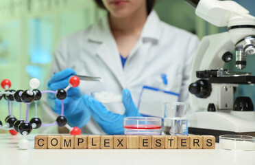A scientist examines complex esters using specialized lab equipment, showcasing chemistry in action.