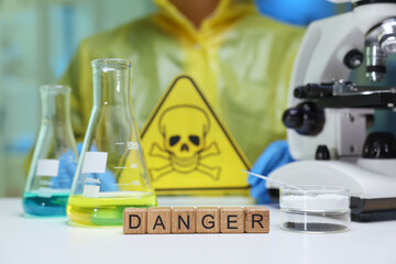 A detailed laboratory scene showcasing prominent danger signs, various chemicals, and essential...