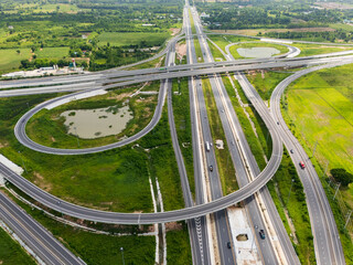 Drone shot a large highway interchange crossing over green farmlands in Thailand