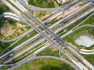 Drone shot a large highway interchange crossing over green farmlands in Thailand