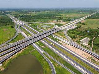 Drone shot a large highway interchange crossing over green farmlands in Thailand