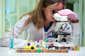 A dedicated scientist is conducting intricate research while using a microscope in an organic...