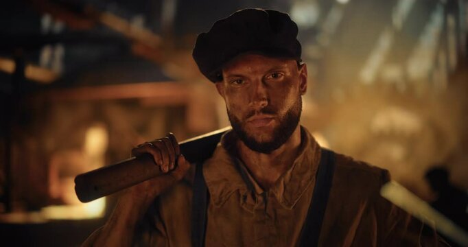 19th-Century Caucasian Male Ironworker Poses for Camera with a Sledgehammer Inside a Fire-Lit Historical Foundry. His Worn Face and Heavy Gear Reflect the Grit and Endurance of Early Industrial Labor