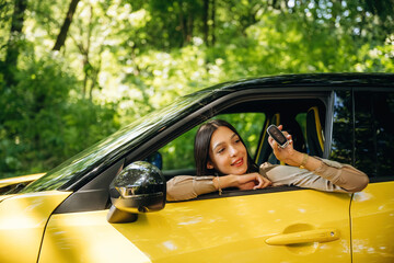 Woman is with her car in the forest