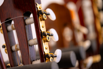 Classical guitars in a stand. Musical instruments macro close-up of the tuning pegs (machine heads)...