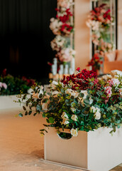 Elegant floral arrangement in a white box as part of luxury wedding stage decor with roses and...