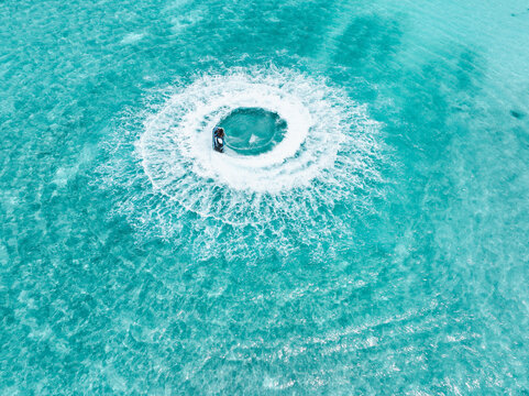 Aerial view of a jet ski creating a swirling vortex in the turquoise waters, Gulhi, Kaafu Atoll, Maldives.
