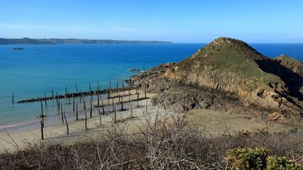 Gwin Zegal tree trunk port in Plouha, France. Medieval harbor with wooden stake in the bay in...