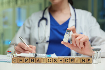 A healthcare professional examines a cephalosporin vial, highlighting its significance in treatment.