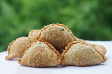 Homemade crispy golden brown curry puffs or karipap in Thai. Concept, traditional snack. A beloved savory pastry filled with spiced fillings, perfect for tea time or festive gatherings. 