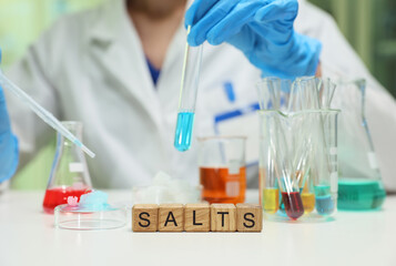 A dedicated scientist meticulously conducts experiments involving colorful salt solutions in a...