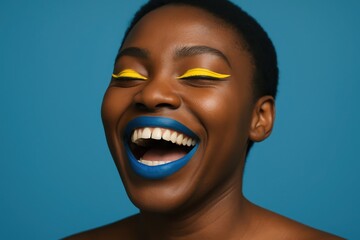 A woman laughs with vibrant blue lipstick and yellow eyeliner