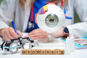 This setup for eye examination includes an eye model and illustrates the concept of mydriasis in detail