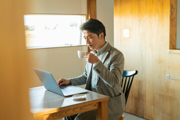 カフェでノートパソコンを操作する男性
