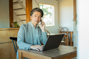 カフェでノートパソコンを操作する男性