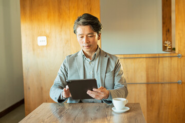 タブレットを使う中年男性