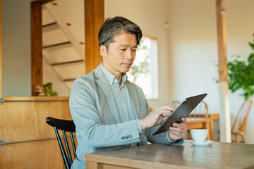 タブレットで作業する30代男性
