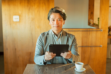 カフェでタブレットを見る男性