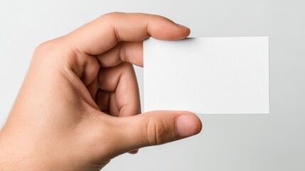 Obraz premium Top-down view of hand offering a blank white ticket, thumb and fingers positioned naturally, isolated on white background, perfect for digital pass or gift card presentations