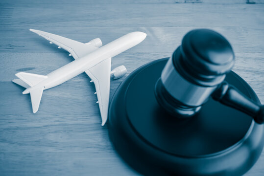Judge hammer gavel and airplane on wooden table background. International Air Law (IAL), aviation law concept.