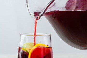 Pouring Smooth Red Sangria Into a Clear Glass With Fruits