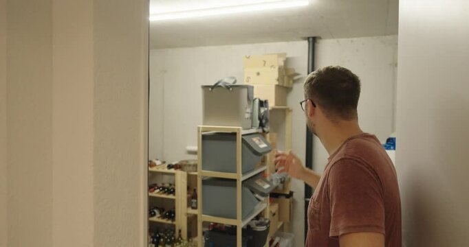 a man stands in front of his warehouse or cellar and is desperate or shocked