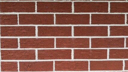 Textured red brick wall with pronounced white mortar — classic architectural background for...