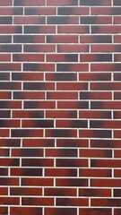 Red brick wall with white mortar lines and black spots — classic texture for architectural, construction, and design projects