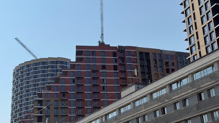 Modern residential high-rise development with construction crane and urban infrastructure —...