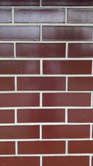 Decorative brown brick wall with glossy finish and light joints — modern texture for architectural projects, facade design, and graphic applications