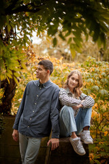 Young Cute Female Hugs Boyfriend. In Autumn Outdoor. Lovers Walking in Park. Attractive Funny Couple. Lovestory in Forest. Man and Woman. Cute Lovers in the Park. Family Concept. Happy Couple.