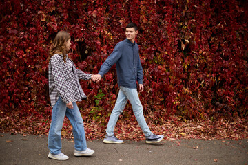 Young Cute Female Hugs Boyfriend. In Autumn Outdoor. Lovers Walking in Park. Attractive Funny Couple. Lovestory in Forest. Man and Woman. Cute Lovers in the Park. Family Concept. Happy Couple.