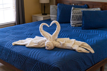 Two Towel Swans Forming a Heart on Bed. Romantic Hotel Room Decor.