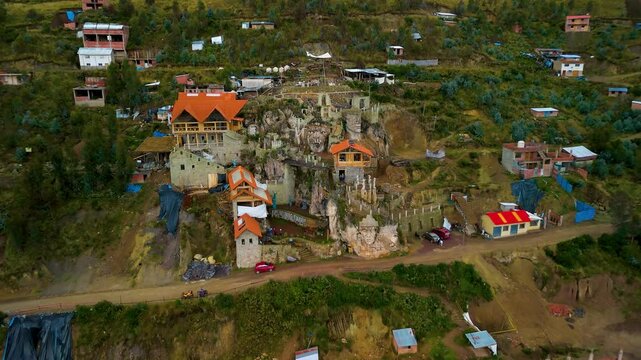 'Morada de los Dioses' (Home of the Gods), a unique modern sculpture park near Cusco, Peru, with giant stone faces carved into the mountainside - pull-back aerial reveal