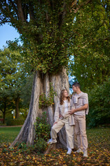 Young Cute Female Hugs Boyfriend. In Autumn Outdoor. Lovers Walking in Park. Attractive Funny Couple. Lovestory in Forest. Man and Woman. Cute Lovers in the Park. Family Concept. Happy Couple.